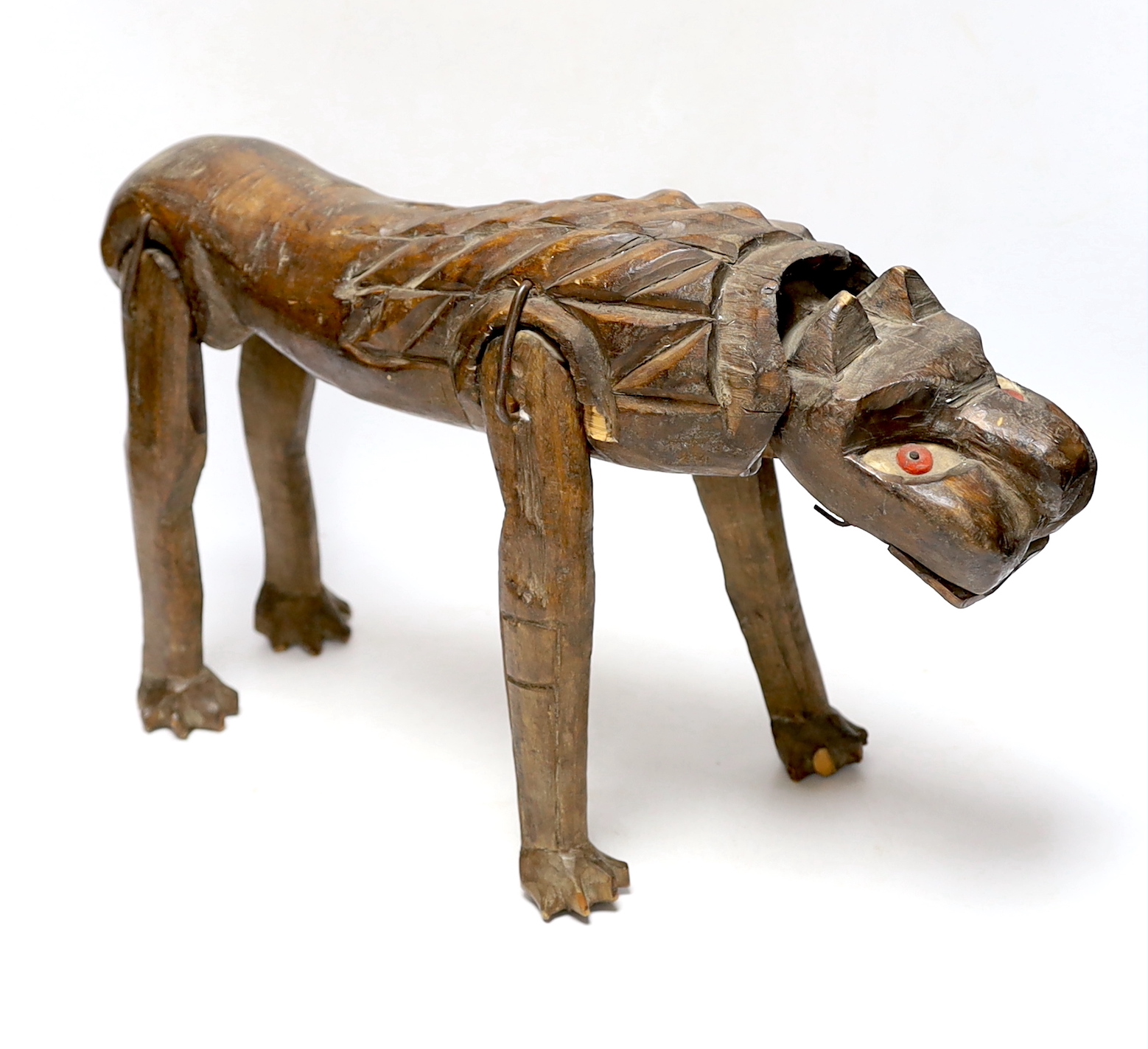 An primitive African articulated wood model of a lion, 41cm wide